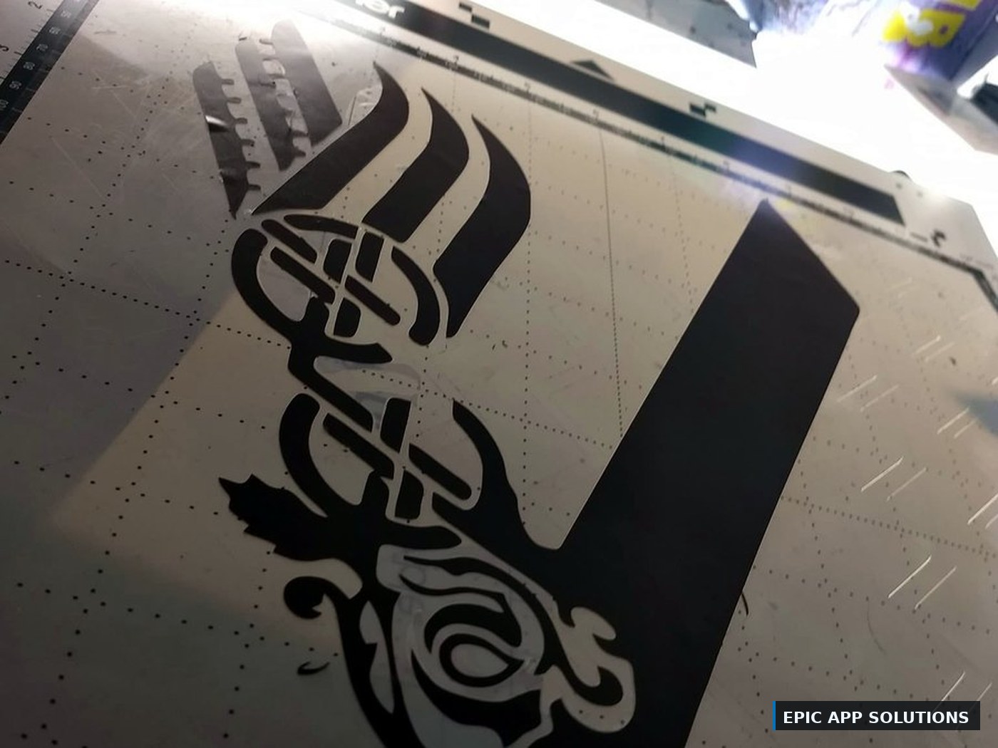 Custom knotwork graphic being cut and weeded on vinyl
